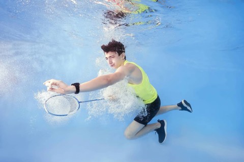 Teen plays badminton underwater
