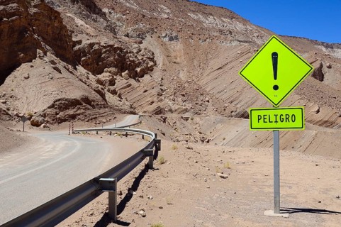 Warning sign in front of a curve