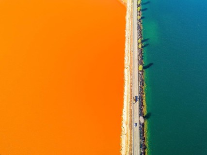 Street trough orange and blue lakes in mining region