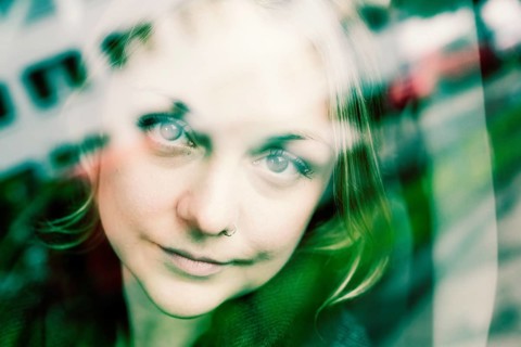 Young woman behind a mirrored glass pane