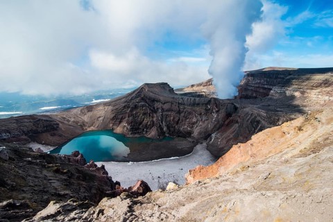 Steaming fumarole with crater lake on the Gorely volcano