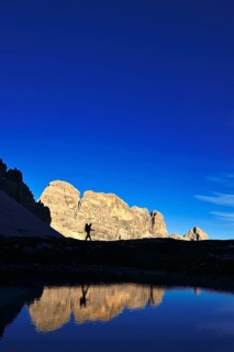 Hiker on the lake in the backlight