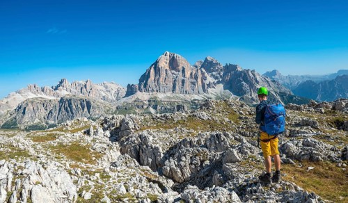 Hiker with climbing helmet on hiking trail to Nuvolau
