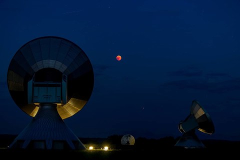 Parabolic antennas with blood moon at lunar eclipse
