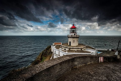 Lighthouse Farol da Ponta do Arnel at the sea