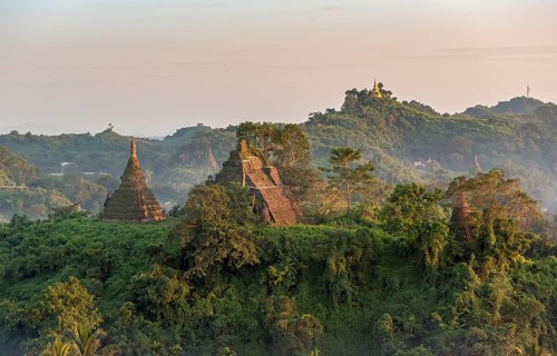 Mist over hills and stupas of Mrauk U at sunset