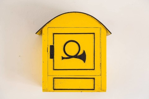 Old yellow mailbox with post horn
