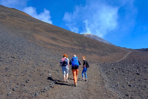 Hikers climbing through volcanic landscape