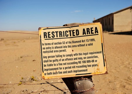 Entrance to the diamond fields Forbidden Shield standing in the sand next to the former diamond city