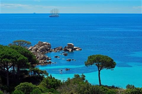 Bay of Palombaggia with turquoise blue sea and sailing ship