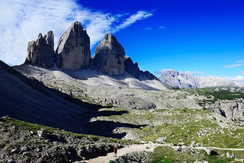 Hiker below the alpine hut in front of the northern walls of the Three Peaks of Lavaredo