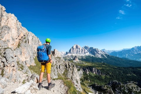 Hiker with climbing helmet on hiking trail to the Nuvolau