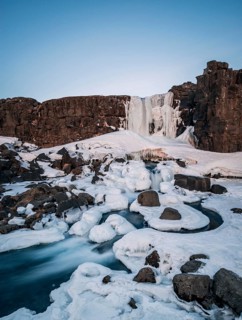 Partially frozen waterfall Oxararfoss in winter