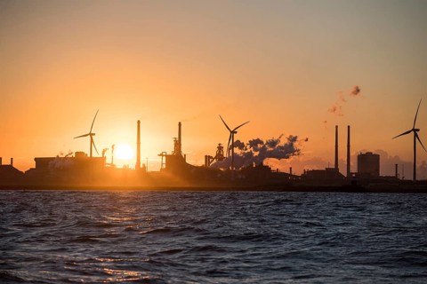 Harbour entrance with wind turbines and the Tata steelworks at sunset
