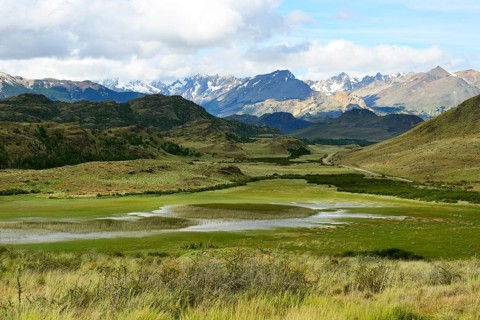Meandering brook in front of mountain landscape