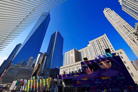 Construction site with graffiti decorated walls in front of the Oculus