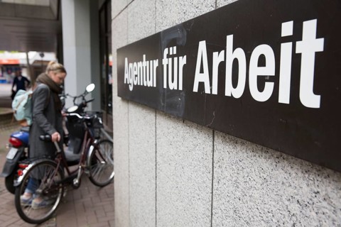 Young woman parks her bicycle in front of the Employment Agency