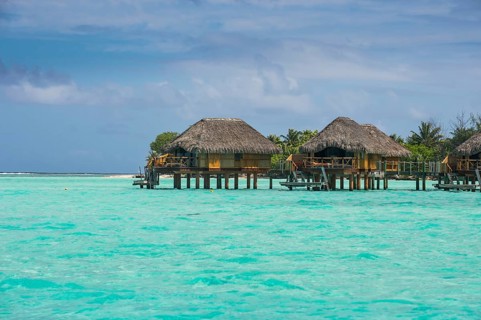 Overwater bungalows on stilts in luxury hotel