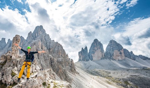 Hiker on the via ferrata to the Paternkofel with summit of the Paternkofel and north faces of the Three Peaks of Lavaredo
