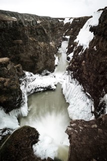 Partially icy waterfall in a canyon