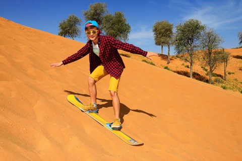 Tourist with Snowboard on the Dune