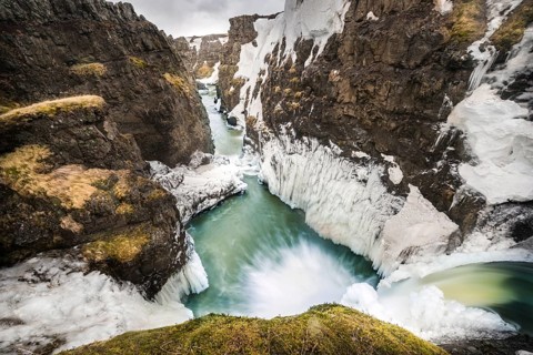 Partially icy waterfall in a canyon