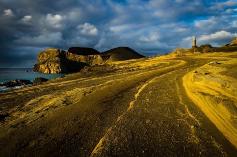Rocky coast with lighthouse Farol da Ponta dos Capelinhos