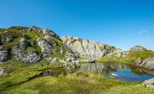 Two hikers at a small lake