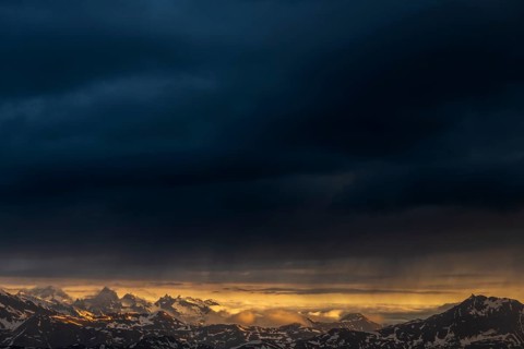 Sunrise over South Tyrolean mountains with dark rain clouds