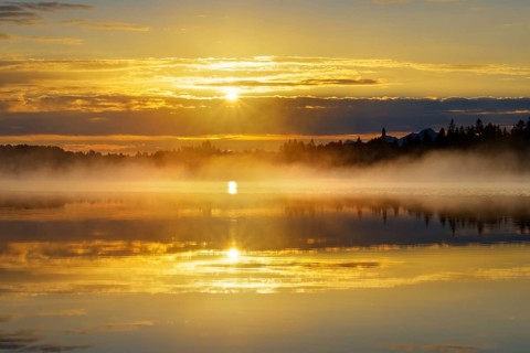 Sunrise with early morning mist over Kirchsee with Reutberg Monastery
