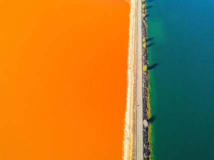 Street trough orange and blue lakes in mining region