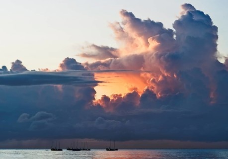 Fishing boats at sunrise in front of dramatic clouds