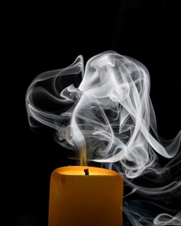 Smoky candle in front of a black background