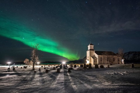 Northern lights over cemetery and church of Gimsoy