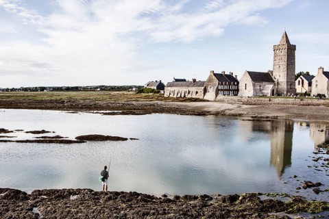 Angler in the mud flats in front of the village of Portbail