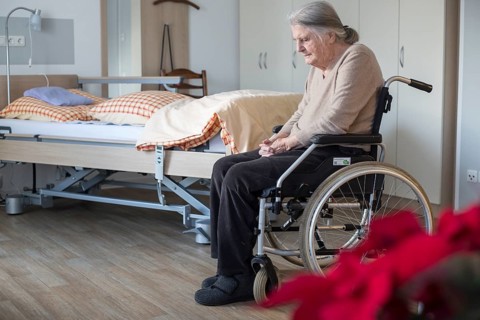 Demented Senior in a wheelchair alone in her room in a nursing home