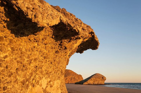 Fossilized lava tongues and walls at the beach Playa del Monsul