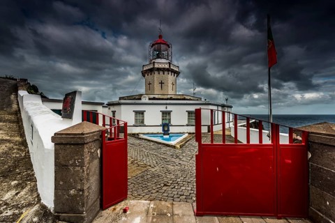 Lighthouse Farol da Ponta do Arnel at the sea