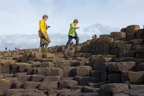 Tourists walk on the basalt columns