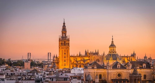 View of La Giralda and Iglesia del Salvador at sunset