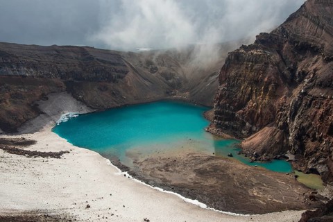Steaming fumarole with crater lake on the Gorely volcano