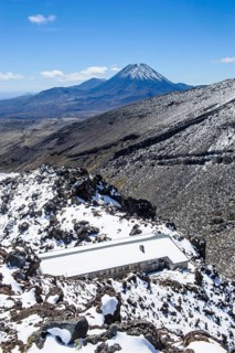 View from Mount Ruapehu on Mount Ngauruhoe with a ski cottage in the foreground