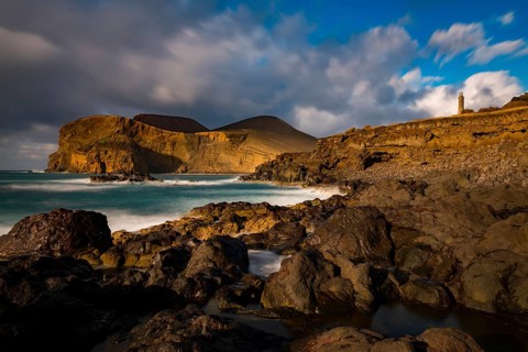 Rocky coast with lighthouse Farol da Ponta dos Capelinhos
