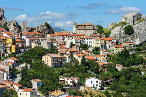 View of mountain village Pietrabbondante with medieval tower and church Chiesa di Santa Maria Assunta on rock Morg Caraceni