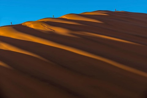 Tourists climb on a sand dune in the Sossusvlei