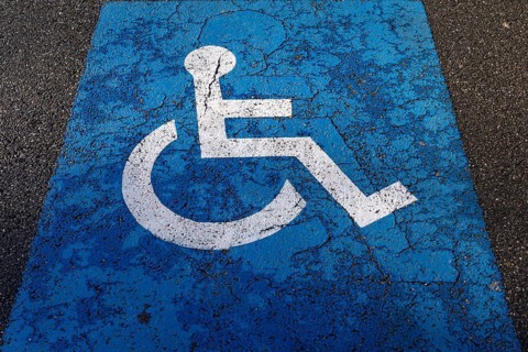 Sign for parking for people with disabilities on torn tar