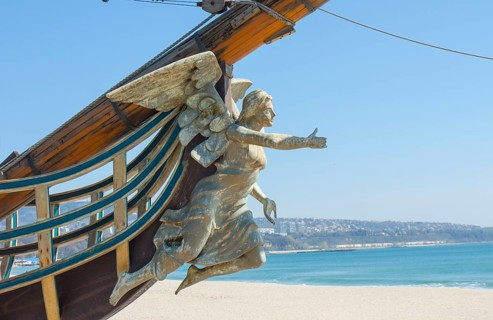 Sailing ship with angel as figurehead on beach