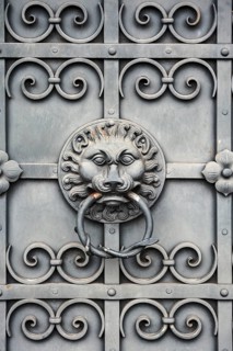 Iron gate with lion's head as door knocker