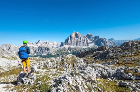 Hiker with climbing helmet on hiking trail to the Nuvolau