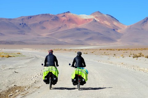 Two cyclists with luggage ride on the runway of the lagoon route